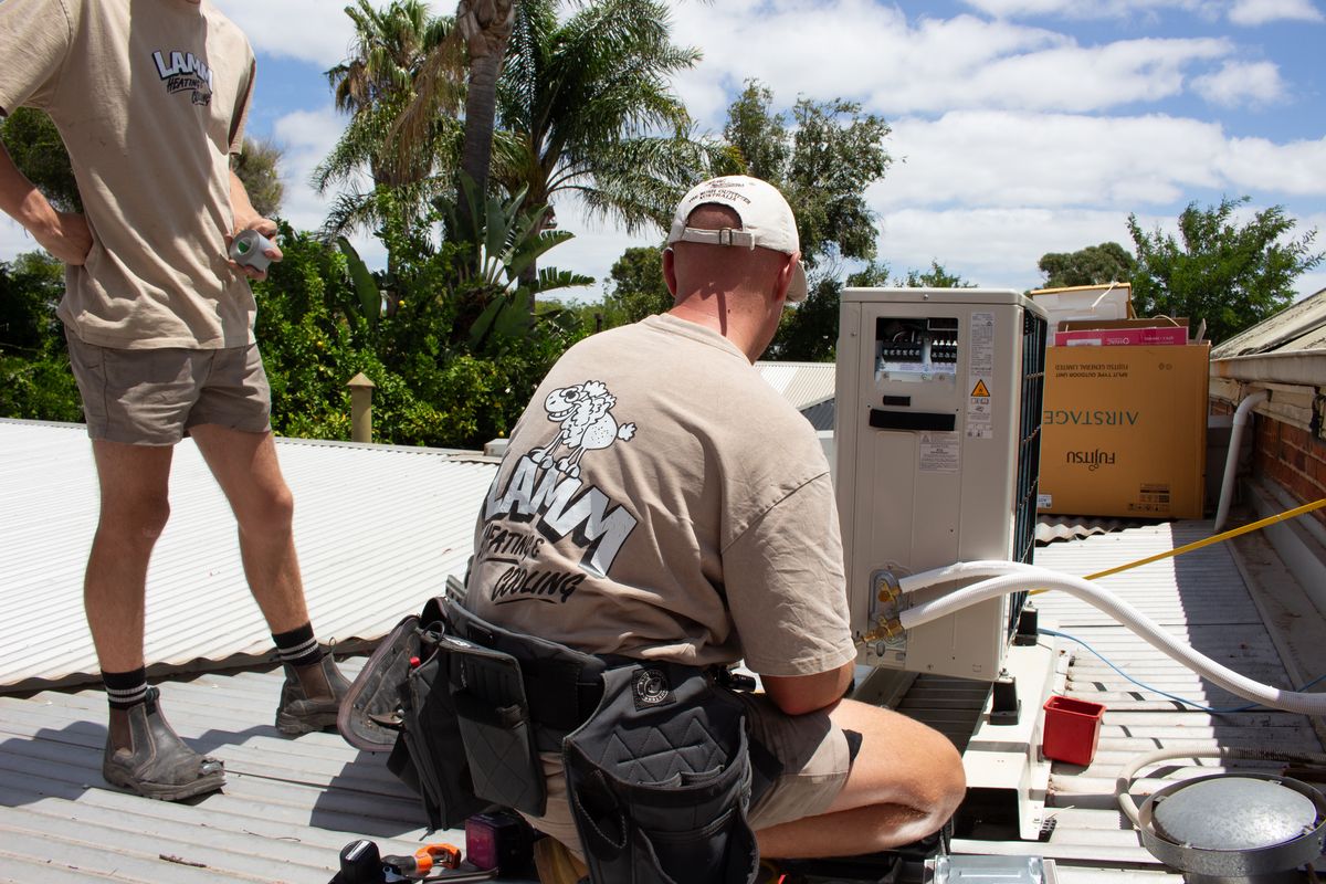 Lamm installing a ducted air conditioning unit on a rooftop